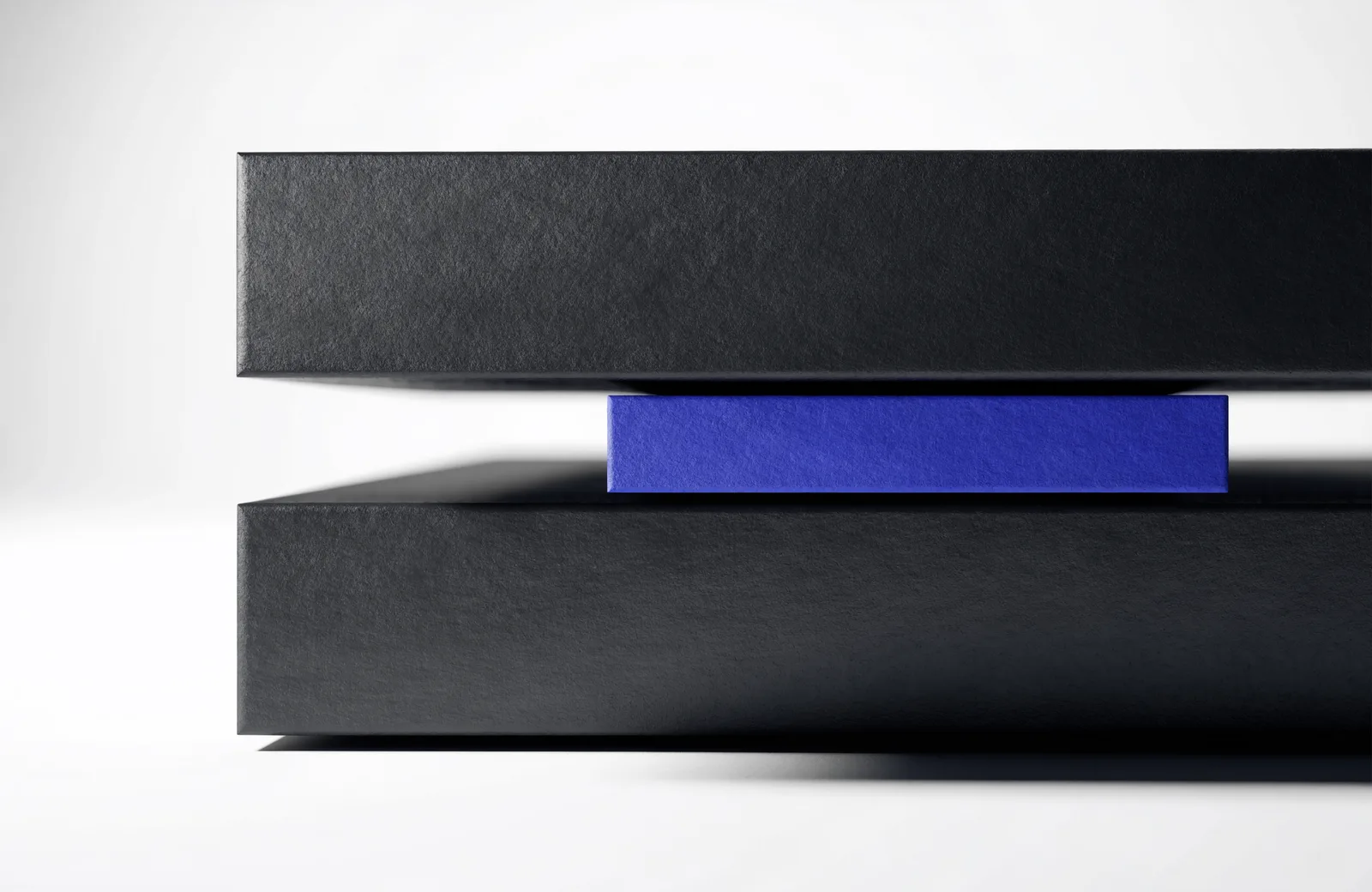 Two large black slabs separated by a gap, with a thinner blue slab carrying the weight between them.