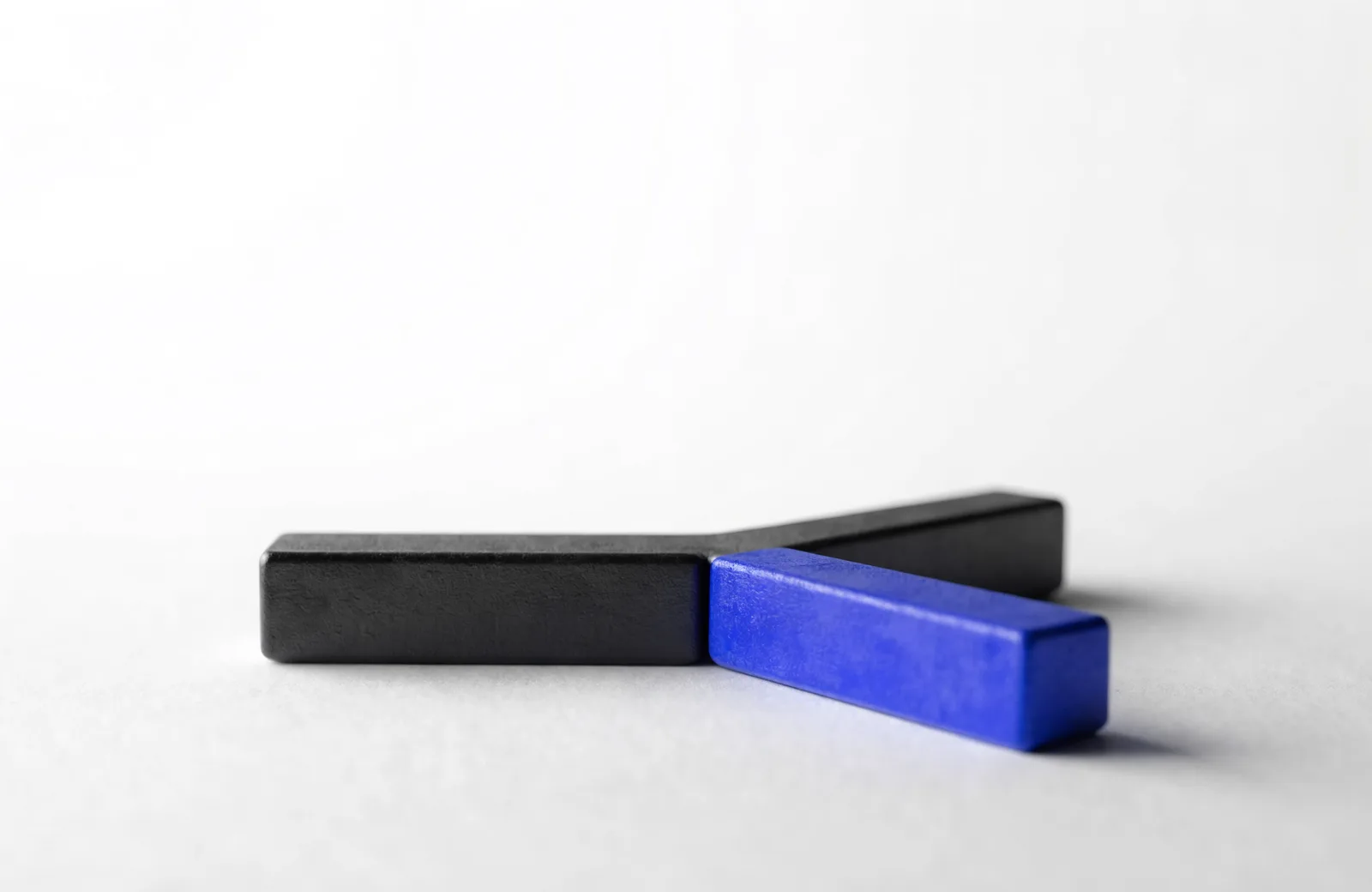 A single black bar dividing cleanly into two equal diverging bars, one of them blue.
