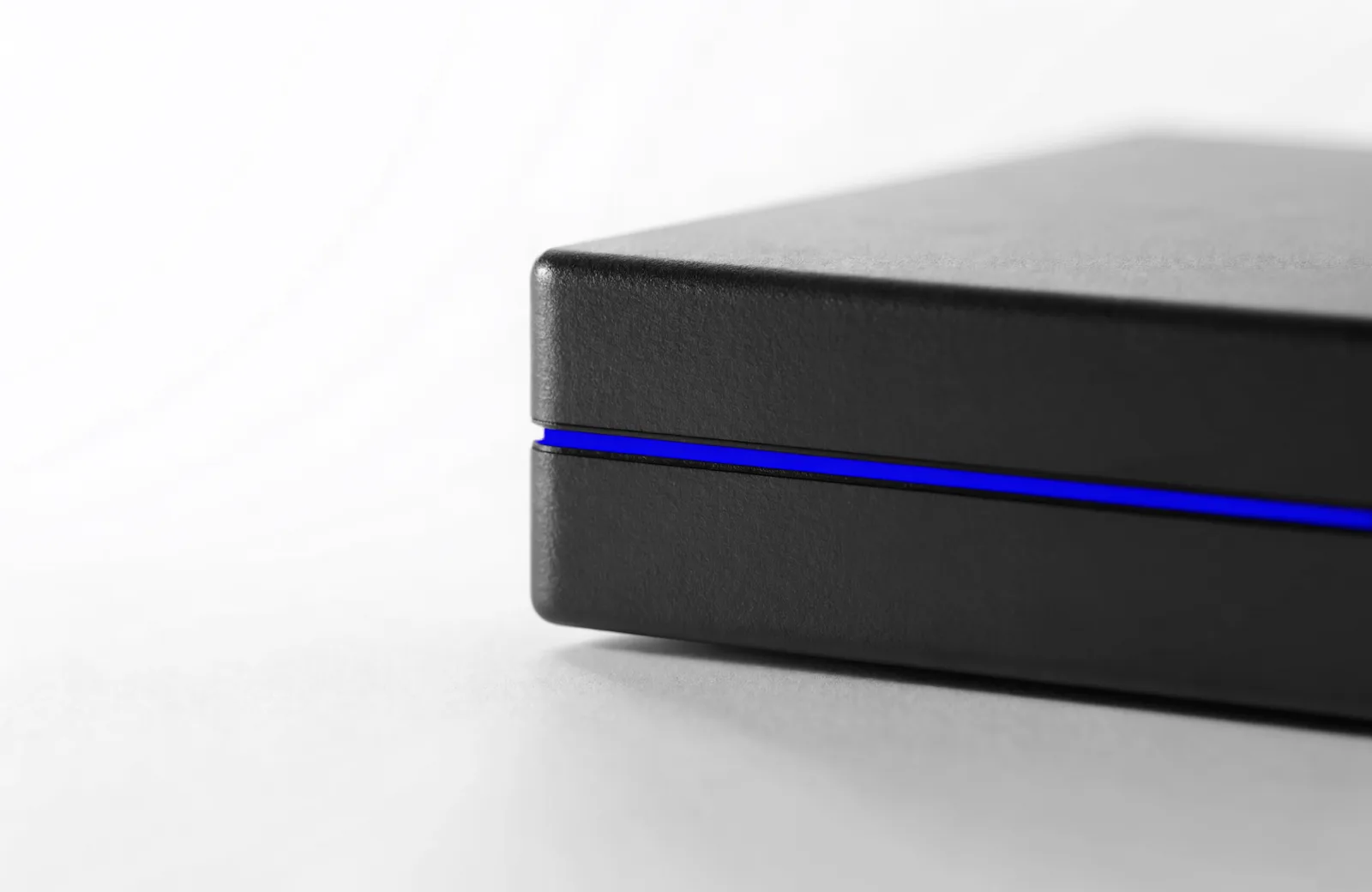 A solid sealed black block with one continuous blue seam running around it.